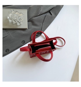 Vue de dessus d'un mini sac cabas en cuir rouge embossé avec compartiment zippé