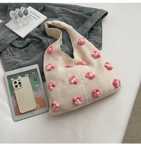 Détail du sac cabas en crème tissé main avec décorations de fleurs au crochet roses et jaunes