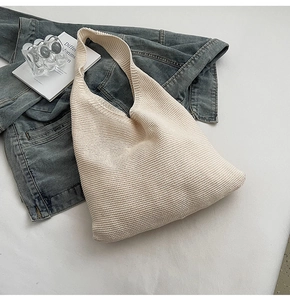 Détail du sac bandoulière en maille blanc cassé montrant la texture ondulée douce