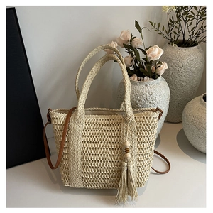Detail of woven straw bag showing fine mesh pattern, leather strap and tassel accents