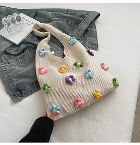 Détail du sac en tricot crème avec broderies de fleurs colorées en relief faites à la main