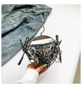 Detailansicht einer Mini-Tasche mit Leopardenmuster und goldenem Metallschmetterling