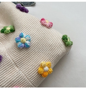Gros plan d'un sac à bandoulière en tricot blanc avec détails de fleurs au crochet