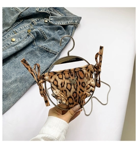 Detail einer Bikinihose mit Leopardenmuster, Rüschen und silbernem Schmetterlingsanhänger