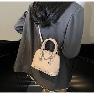 Vista posteriore della borsa beige con catena d'argento e ciondoli a forma di dadi