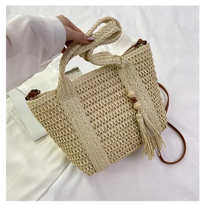 Detail of hand-woven straw bag with fringe, wooden beads and dual shoulder straps