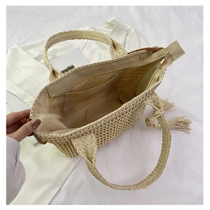 Detail of straw tote bag interior featuring fabric lining and zipper pocket for storage