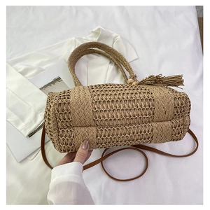 Detailed macro view of straw woven bag texture with fringe and leather shoulder strap
