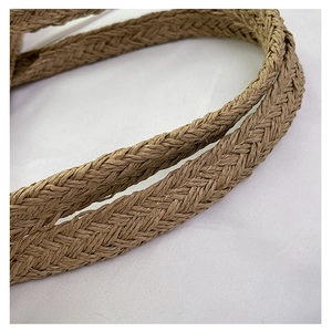 Close-up of natural khaki woven straw handle and texture on a summer beach tote bag