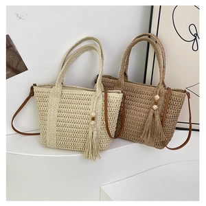 Detailed close-up of woven straw tote bags with tassel charms on a minimalist display