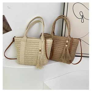Detail of straw woven bags with texture, wooden beads tassels, and leather shoulder straps
