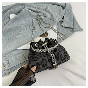 Detailed view of leopard print bucket bag with rhinestone handle and silver chain strap