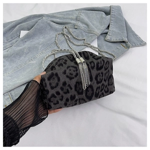 Close-up of leopard print bucket bag with silver metal handle and sparkling rhinestone tassels