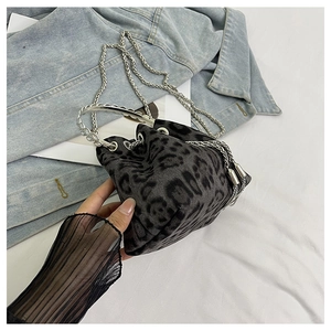 Detail of leopard print bucket bag featuring silver ring handle and chain shoulder strap