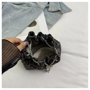 Detailed view of leopard print bucket bag with silver metal chain drawstring closure