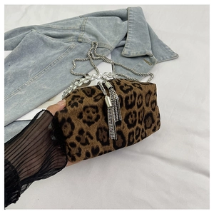 Detail of leopard plush bucket bag with rhinestone handle and metal fringe tassels