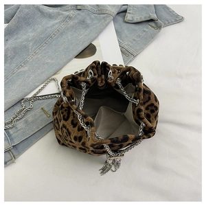 Detail of leopard print bucket bag featuring silver chain straps and metal tassels