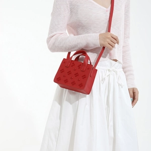 Sac carré rouge à rivets avec appliqués floraux de trèfle et bandoulière élégante
