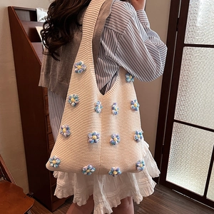Sac bandoulière en tricot beige avec fleurs au crochet bleues et texture tissée