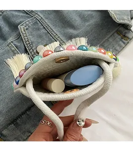 Detail of woven mini bag showing interior storage for lipstick and jewelry