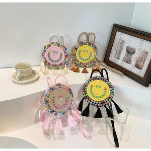 Detailed view of woven round bags with beaded smiley faces and colorful silk tassels