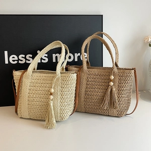 Minimalist straw tote bags in beige and light brown with bohemian tassels for beach use