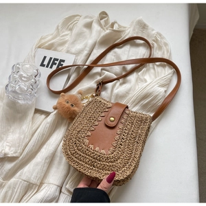 Détail du sac bandoulière en paille avec rabat en cuir et joli charme d'animal en peluche