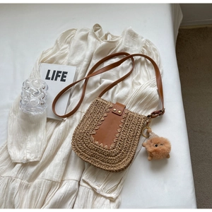 Sac bandoulière en paille avec détails en cuir marron et breloque monstre en peluche