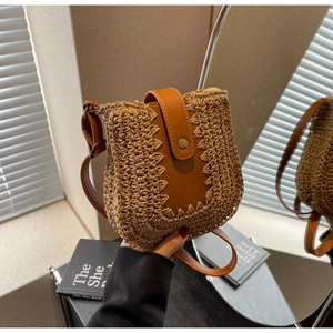 Détail du sac à bandoulière en paille tressée avec bordure en cuir et fermoir magnétique