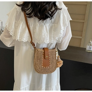 Détail du sac bandoulière en paille fait main avec rabat en cuir et breloque ours