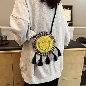 Handwoven yellow round crossbody bag with green beaded smiley face and vibrant fringe