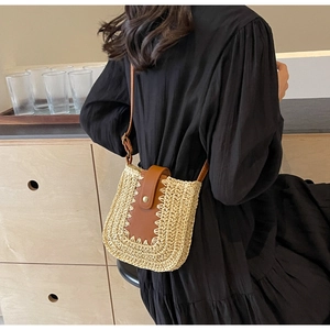 Détail du sac bandoulière en paille avec rabat en cuir marron et fermoir métallique