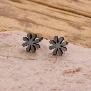 Macro detail of black daisy stud earrings with matte finish on natural pink stone