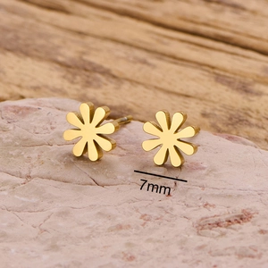 Minimalist 7mm gold stainless steel daisy stud earrings on pink stone background