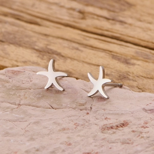 Minimalist starfish stud earrings in polished stainless steel on a natural stone base