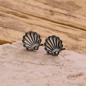 Detail of bohemian black shell studs on pink stone background with rustic wooden texture