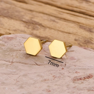 Polished 7mm geometric hexagonal stainless steel gold studs on a natural stone base