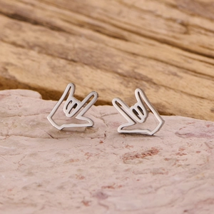 Polished stainless steel hand gesture stud earrings on natural stone background