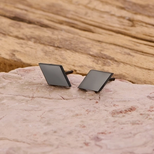 Macro detail of matte black square stainless steel studs on a decorative stone base