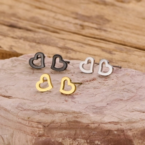 Trois paires de boucles d'oreilles cœur en acier inoxydable en or, argent et noir sur pierre