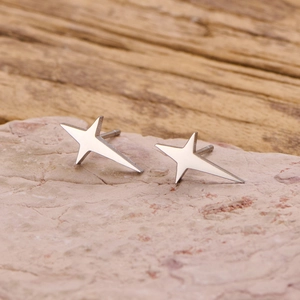 Elegant minimalist silver four-pointed star stud earrings with a polished mirror finish