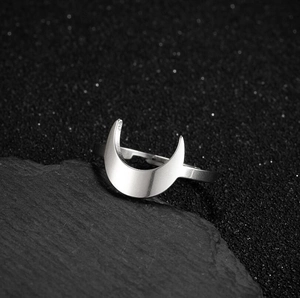 Adjustable silver crescent moon ring with high polish finish on a dark star-themed background