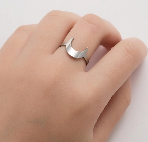 Close-up of minimalist stainless steel crescent moon ring on finger with matte finish