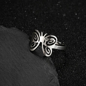 Bague papillon ajustable en acier inoxydable avec ailes en spirale sur fond pierre noir