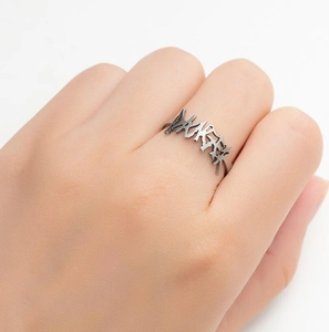 Macro shot of silver stainless steel ring with 'Lucky' cutout design on human finger