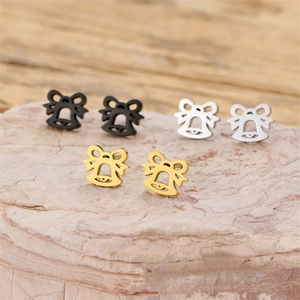 Bowknot bell stud earrings in gold silver and black metal set on a stone background