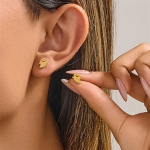 Detailed close-up of golden stainless steel ghost stud earrings for Halloween fashion