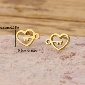 Minimalist gold heart key stud earrings on pink stone showing 0.9cm width dimensions