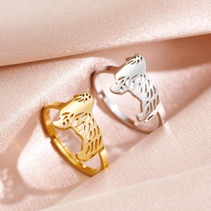 Verstellbare Edelstahlringe mit Hundesilhouette in Gold und Silber auf rosa Seide