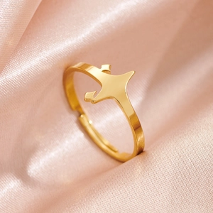 Vue macro d'une bague en acier doré minimaliste sur une texture de tissu satiné rose